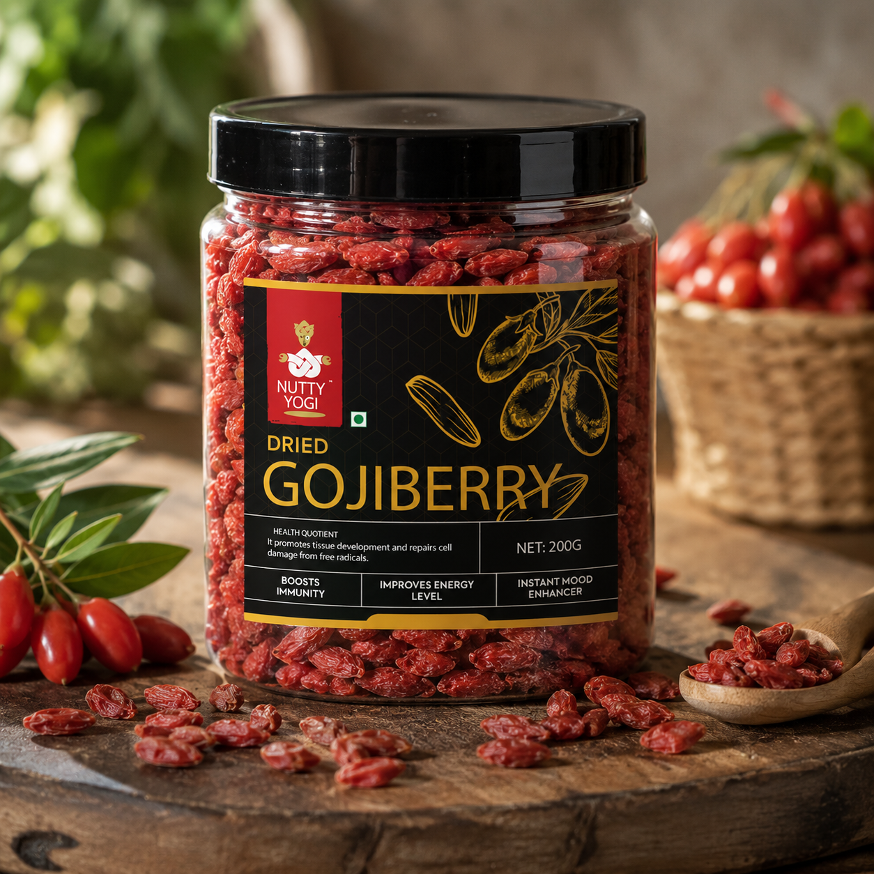 A 200g jar of Nutty Yogi Dried Gojiberry on a rustic wooden table, surrounded by fresh gojiberry berries, leaves, and a wooden spoon with scattered dried berries.