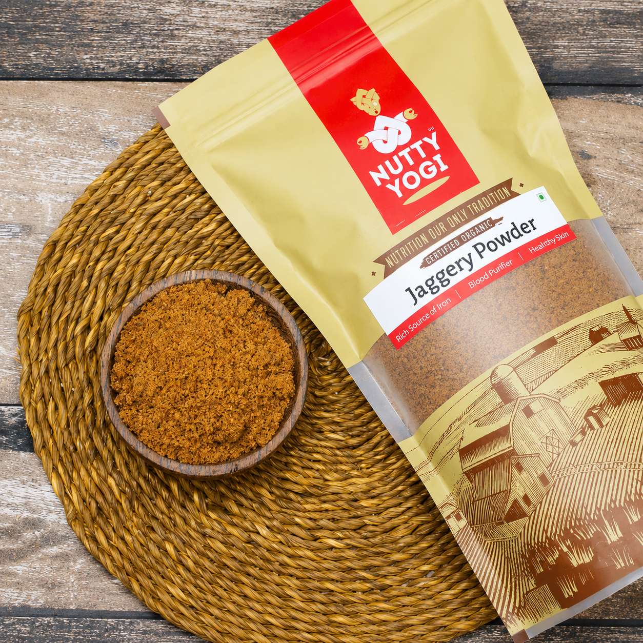 Nuty Yogi jaggery powder package with a bowl of jaggery powder on a woven mat.