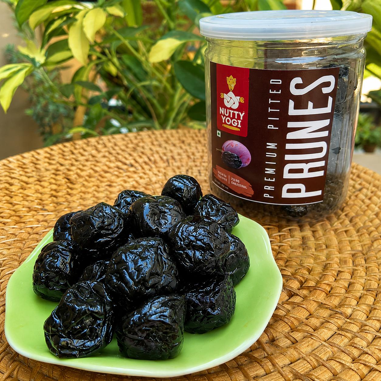 Lifestyle image of Nutty Yogi Premium Pitted Prunes served on a green plate with the product jar in the background, showcasing naturally sweet, ready-to-eat prunes for healthy snacking.
