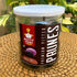 Front view of Nutty Yogi Premium Pitted Prunes jar placed on a woven table outdoors, showcasing healthy snack prunes that support digestion in convenient resealable packaging.