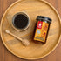 Nutty Yogi Wild Forest Raw Honey jar with a bowl of raw honey and wooden honey dipper on a wooden serving tray
