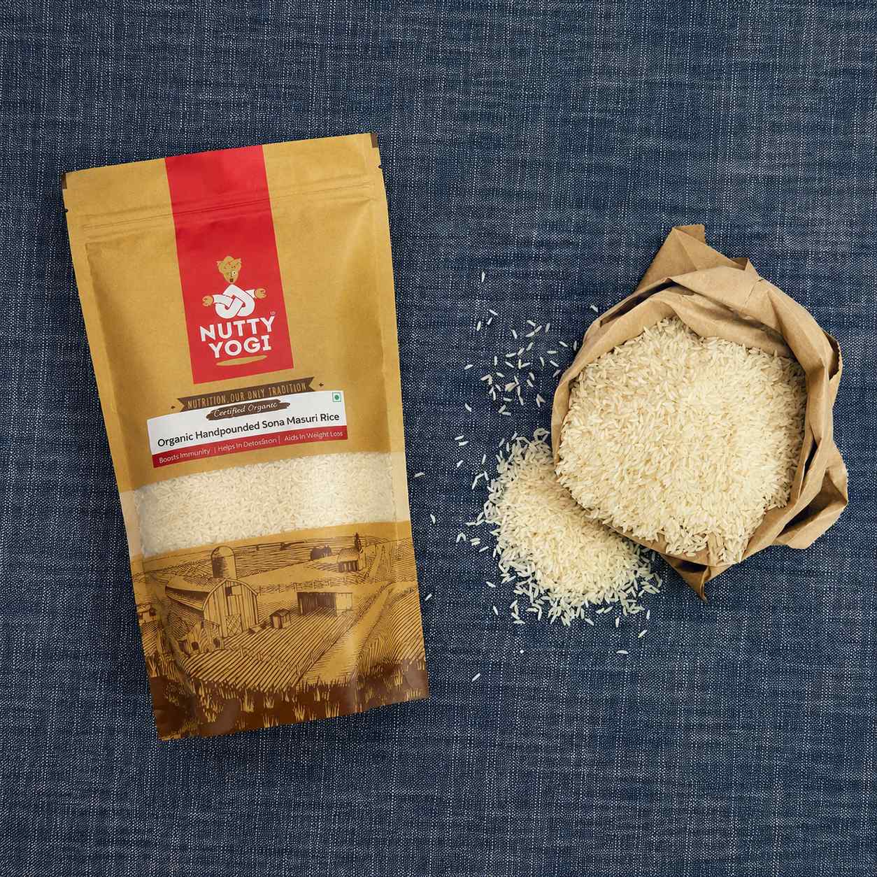 Nutty Yogi Organic Handpounded Sona Masoori Rice displayed beside a paper bag filled with premium Sona Masoori rice grains, highlighting a wholesome, naturally processed rice for everyday meals.