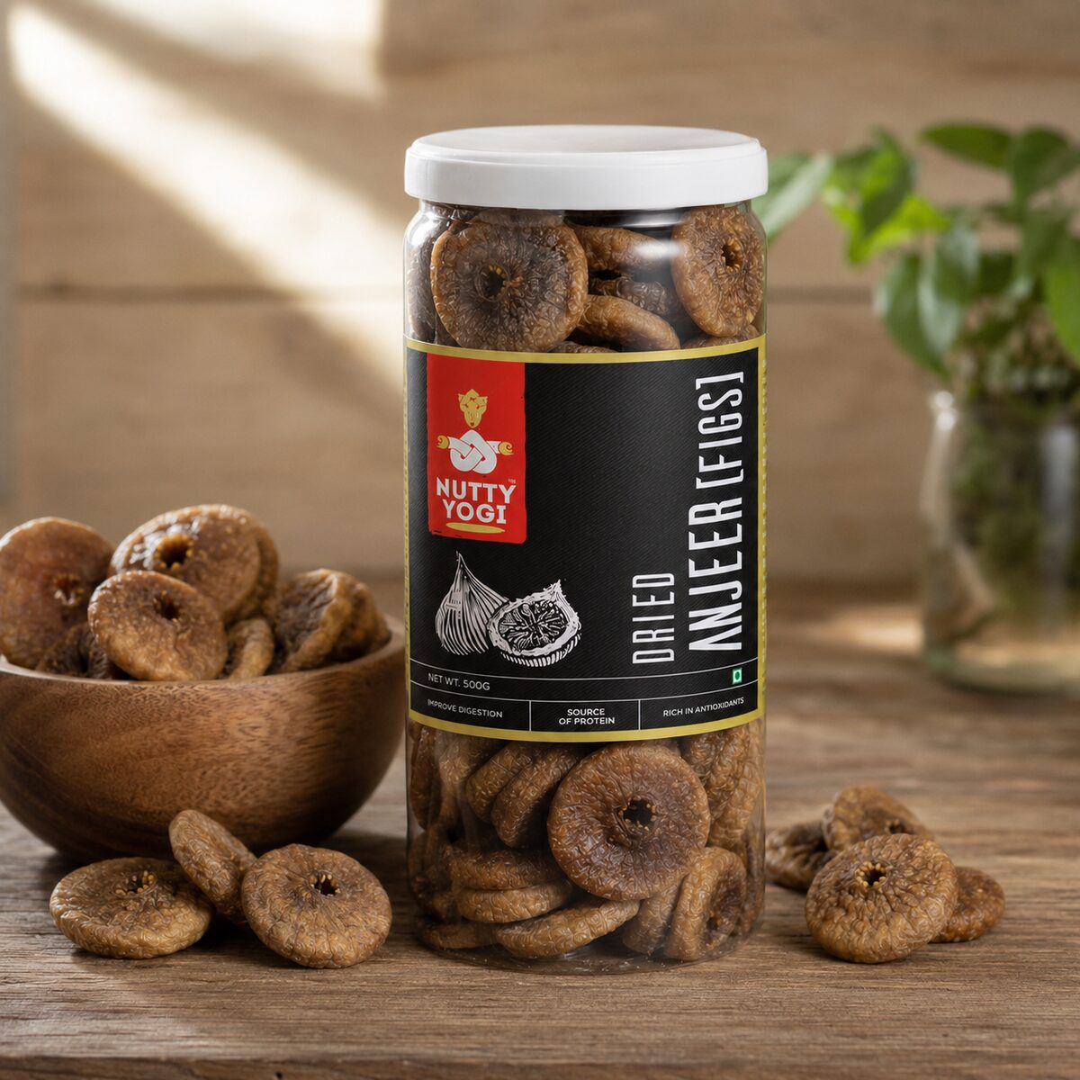 Lifestyle image of Nutty Yogi Dried Anjeer Figs jar displayed with premium dried figs in a wooden bowl, highlighting a natural source of protein, antioxidants, and digestive wellness.